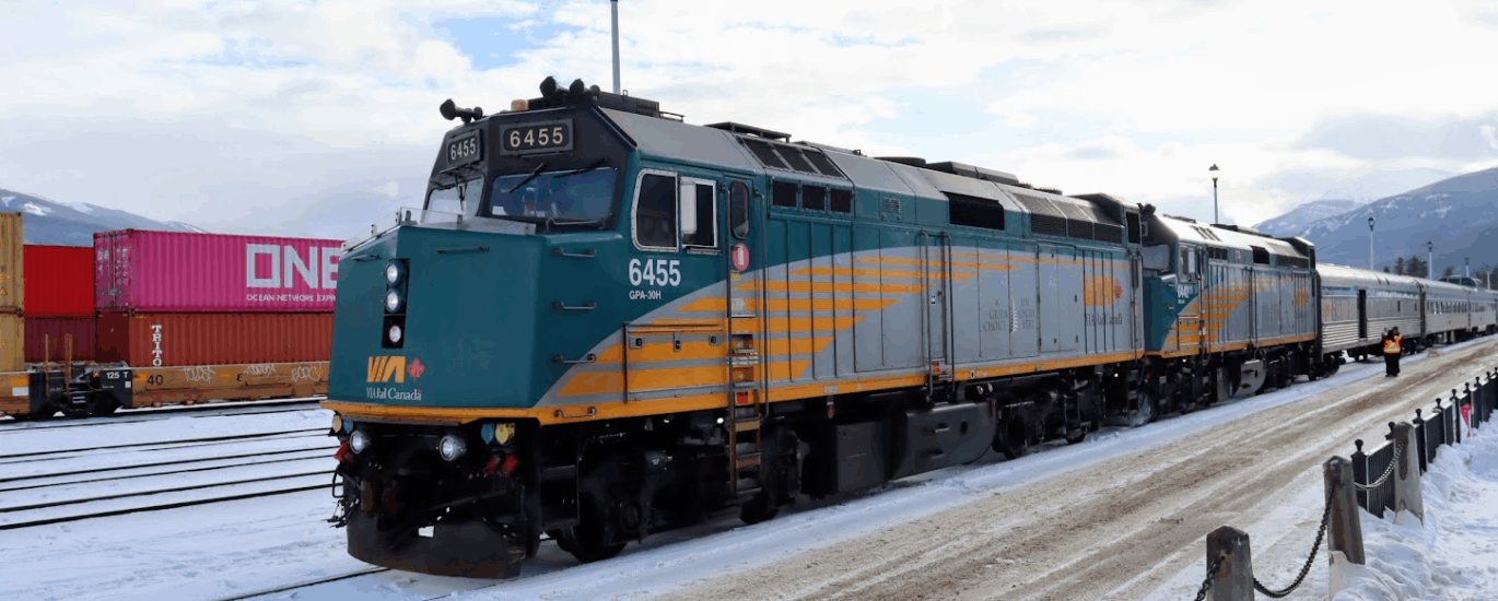 VIA Rail's Canadian at Jasper, Alberta with a light covering of snow on the platform and tracks.