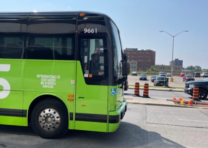 Lime green Flixbus branded motorcoach passing road works.